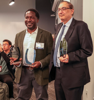 Kimani Toussaint stands on left and Wafik El-Deiry stands next to him on right holding awards